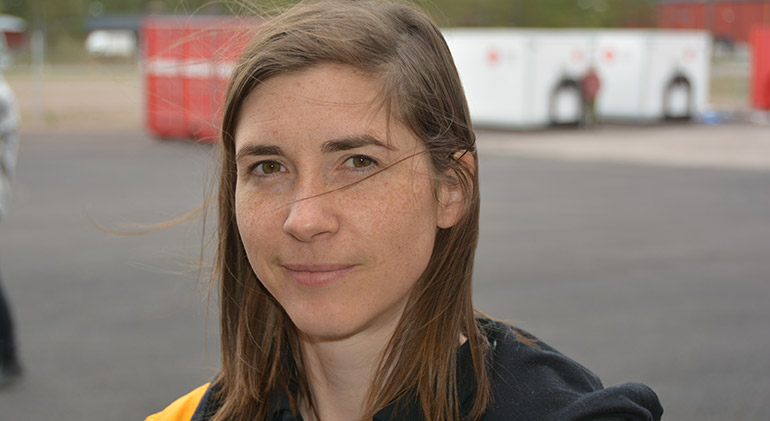 Porträtt på Gunilla Fallqvist, klädd i gult och svart.