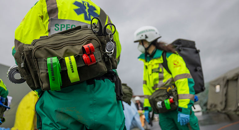 Sjukvårdspersonal med band i rött, gult och grönt på deras ryggsäckar, som de ska använda för att kategorisera sårade.