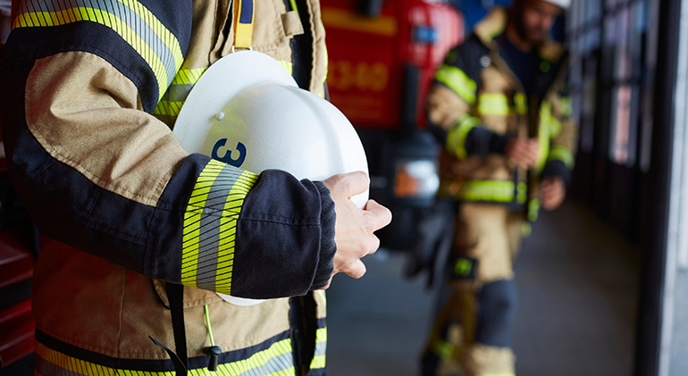 brandman håller en hjälm i händerna
