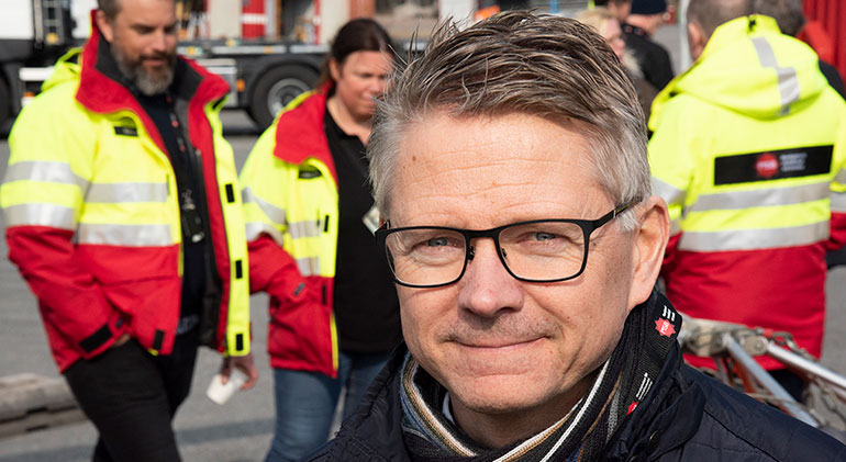 Porträtt på Ulf Lago när han besökte MSB i Kristinehamn, så det är några personer i MSB-jackor i bakgrunden.